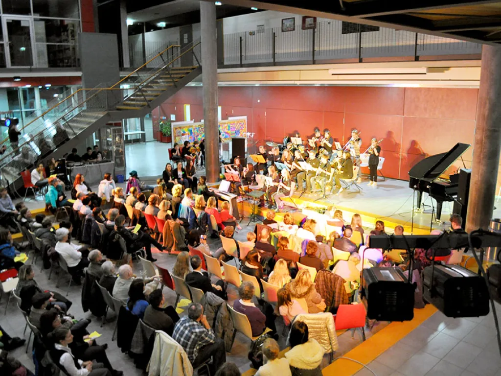 Volles Foyer mit Publikum und Orchester.